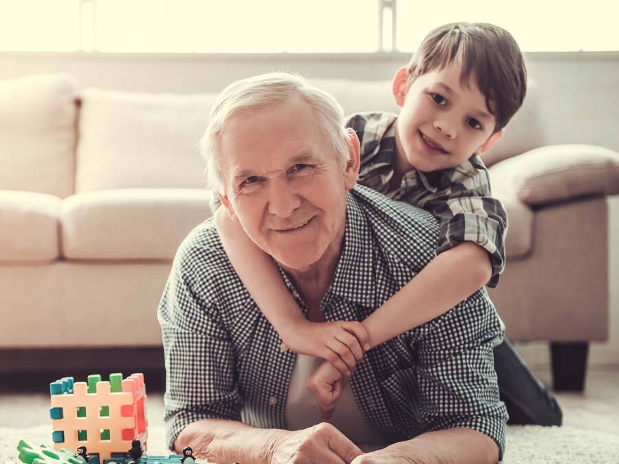 Ein Großvater spielt mit seinem Enkel und denkt über ein Vorausvermächtnis nach.
