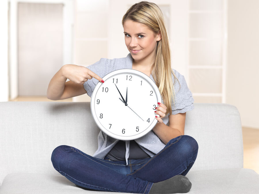 Eine Frau zeigt auf eine Uhr und zeigt damit das eine Frist bald abläuft.