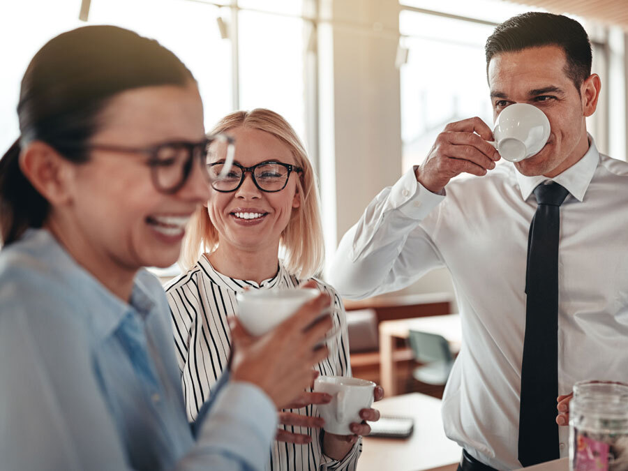 Eine Gruppe von Büroangestellten trinkt Kaffee.