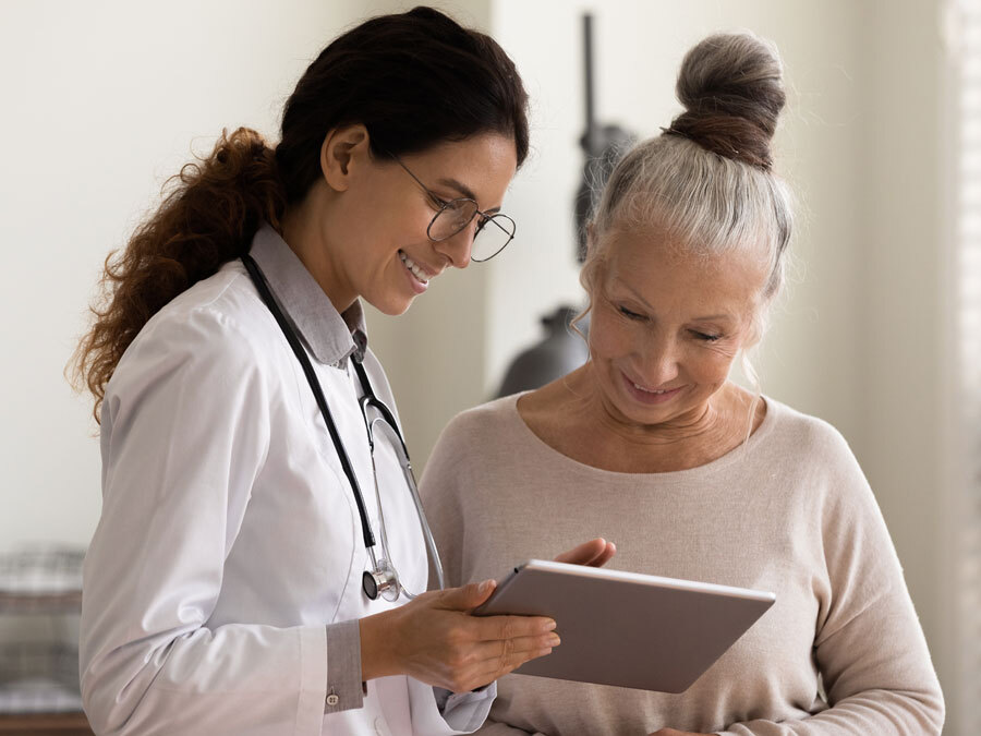 Eine Ärztin und eine Patienten schauen auf ein Tablet.
