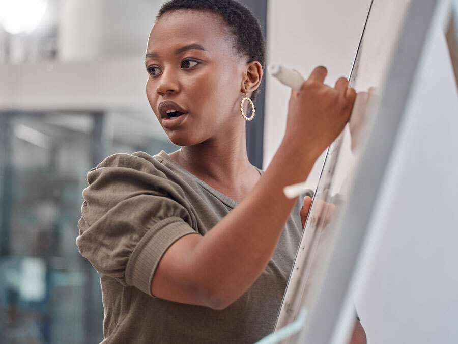 Eine Frau schreibt 10 Regeln für Personaler auf ein Whiteboard.
